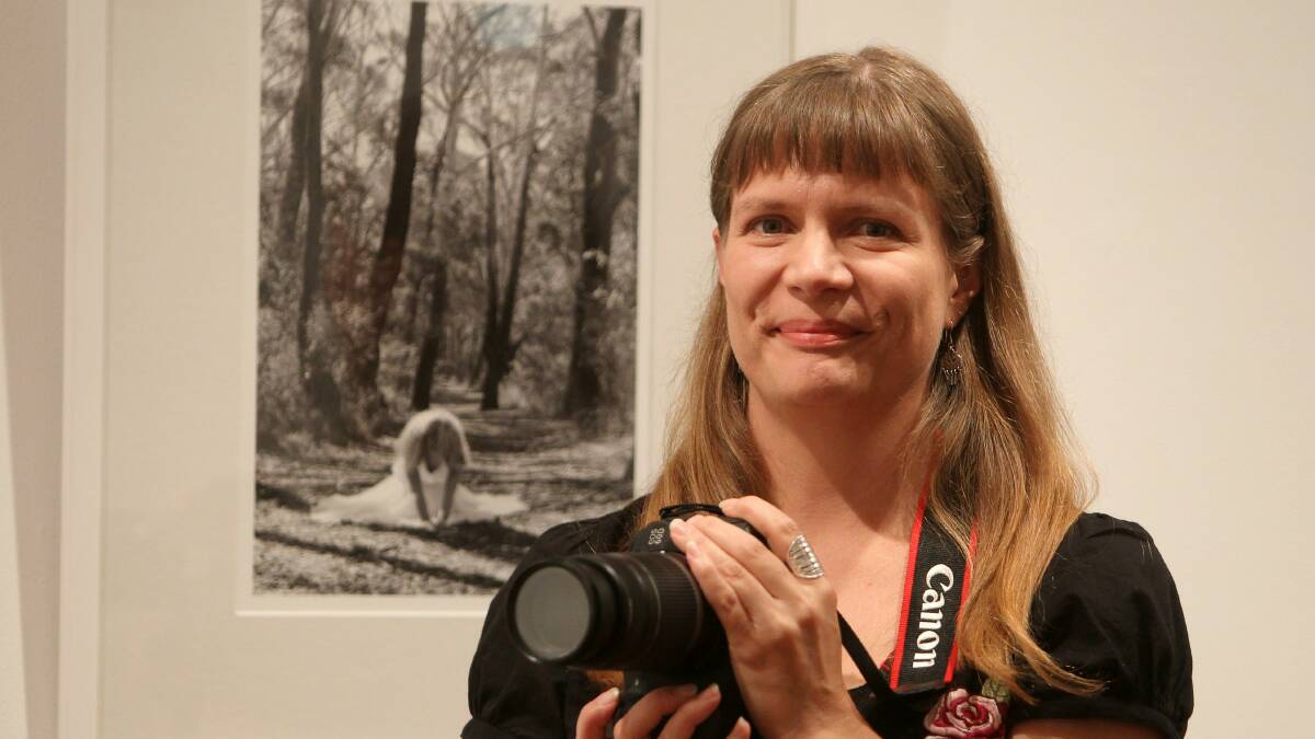 Artist Arja Valimaki with her portrait of a friend, which she took in Blackbutt Forest. Picture: GREG TOTMAN