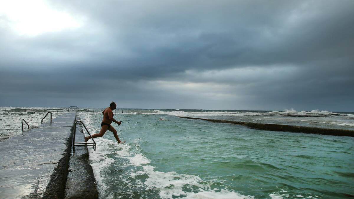 Swimmer Geoff Gorham leaps into the pool at Austinmer this morning. Pictures: KIRK GILMOUR