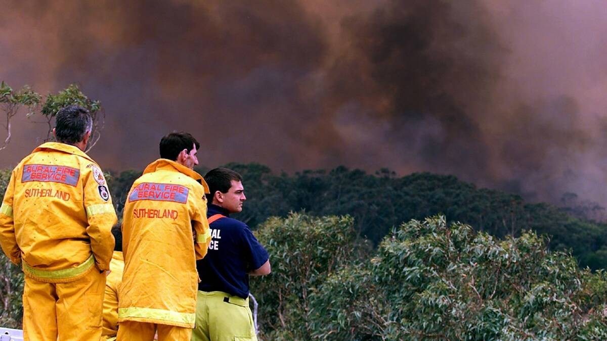 Firefighters watch a huge bushfire move through Heathcote on BOxing Day, 2001. Picture: REUTERS