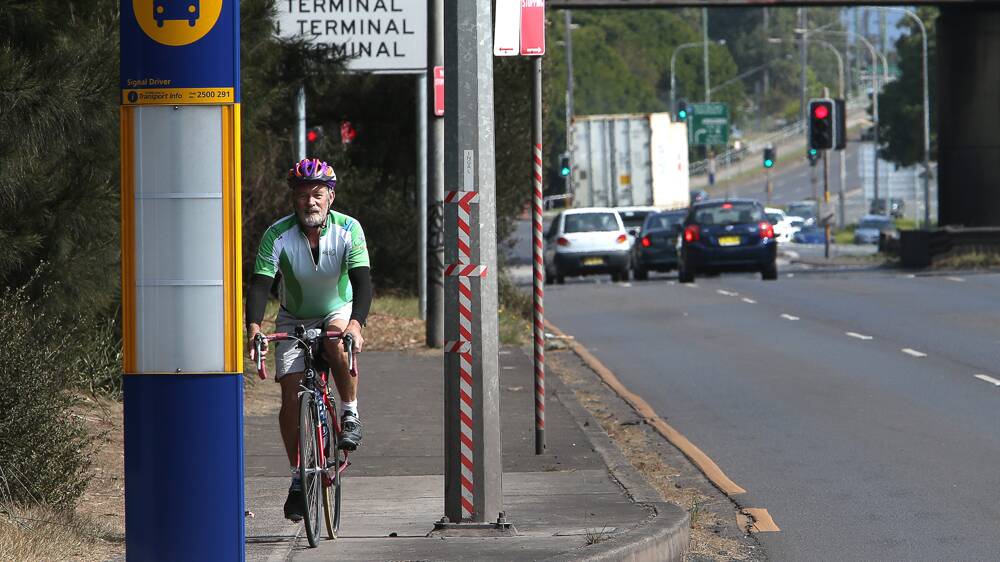IBUG chairman Werner Steyer cycles past a bus timetable plinth on Springhill Road near the intersection with Bridge Street, Coniston. Picture: KIRK GILMOUR