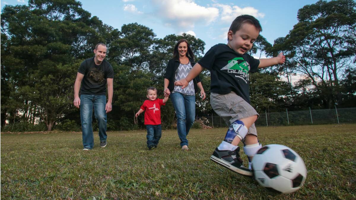 Bulli parents Anthony and Carly Bott and sons Harlan and Ari, who would love to swap his leg braces for a new device that will help him move more easily. Picture: ADAM McLEAN'