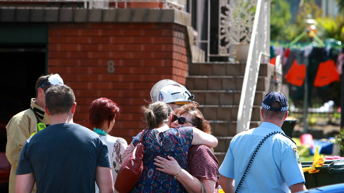 A crowd gathered after fire took hold of the rented home in Burke Road, Dapto. 