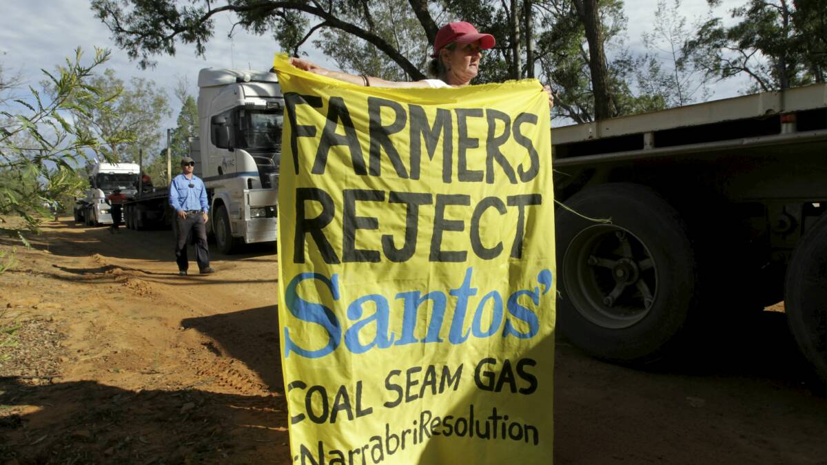 NSW farmers Ted and Julia Borowski (holding banner) protest against Santos' gas project near the Pilliga State Forest. 