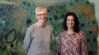 UOW Art Collection director Professor Amanda Lawson and curator Phillippa Webb with a Guy Warren painting, Escarpment. Picture: MELANIE RUSSELL