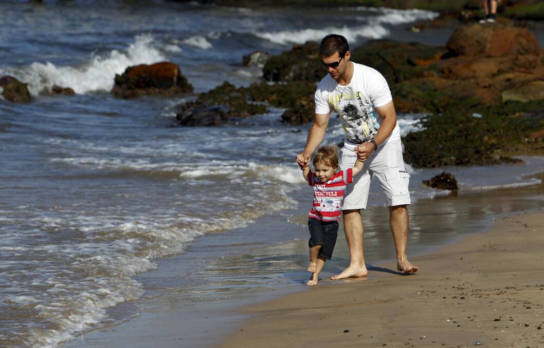 Robert De Ornelas and his son Jesse, 2, play along the water’s edge at Wollongong Harbour. Picture: ANDY ZAKELI