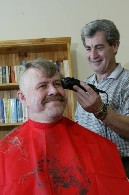Dr Ian Davidson says goodbye to his beard of 18 years, his moustache and his hair to raise money for the Cancer Council as Thirroul barber Hugo Maione does the honours.