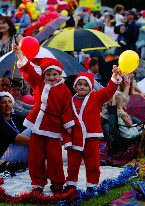  Red rain dears Tia, 5, and Christopher, 4, in the swing of Wollongong's carols.