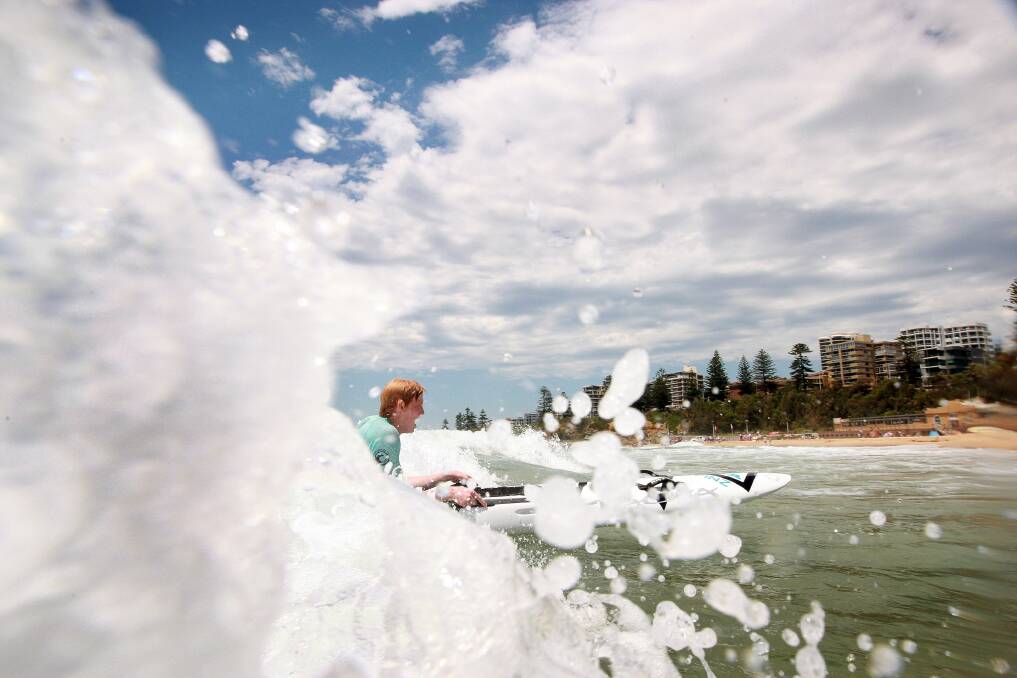 Hawks player Luke Jamieson hits the surf at Wollongong's North Beach. Picture: SYLVIA LIBER