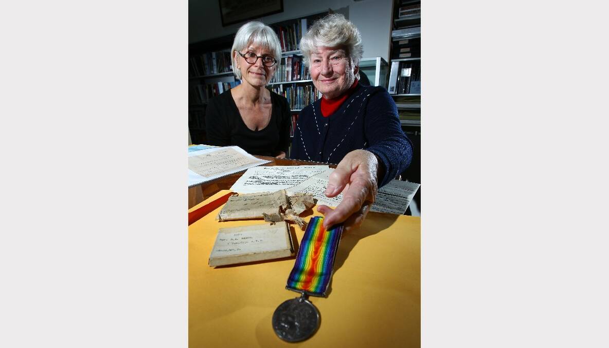 Librarian Marisa O’Connor with Dawn Wright and documents and a medal from her husband’s stepfather. Pictures: KEN ROBERTSON