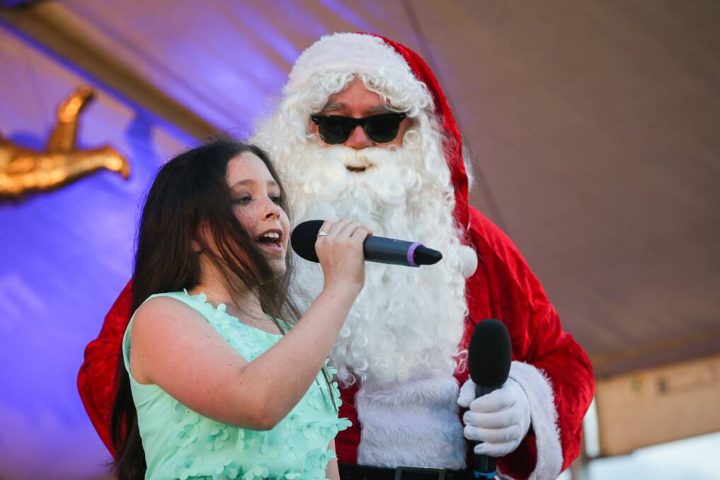 Santa and McKenzee Scrine on stage at Reddall Reserve. Picture: ADAM McLEAN
