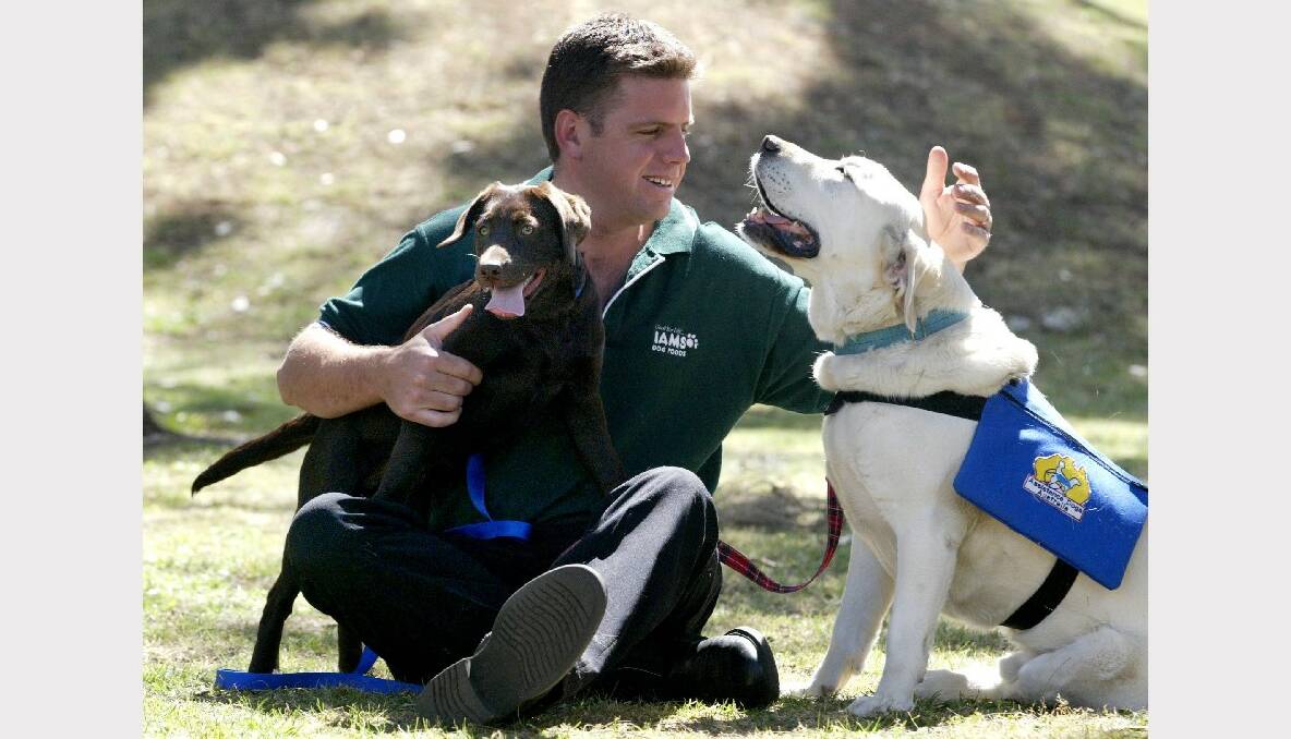 Assistance Dogs Australia chief Andrew Biggs with puppy Amy and six-year-old Oscar.