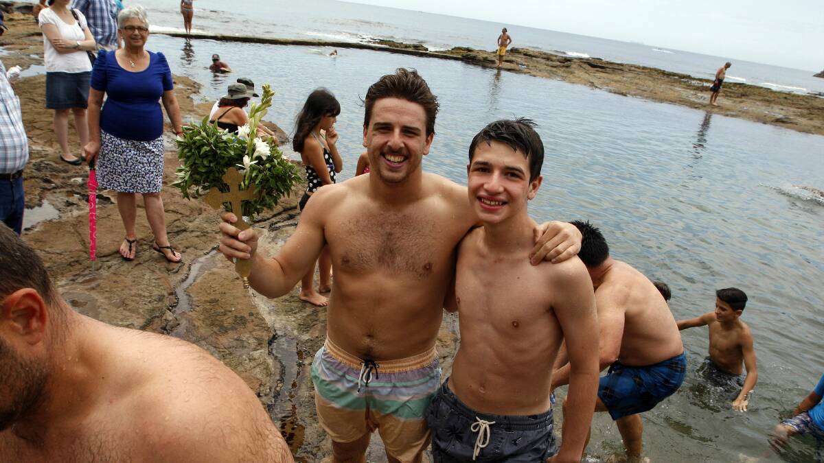 Jordan Wallace, left, was the first to retrieve the cross from North Wollongong rock pool. Pictures: ANDY ZAKELI