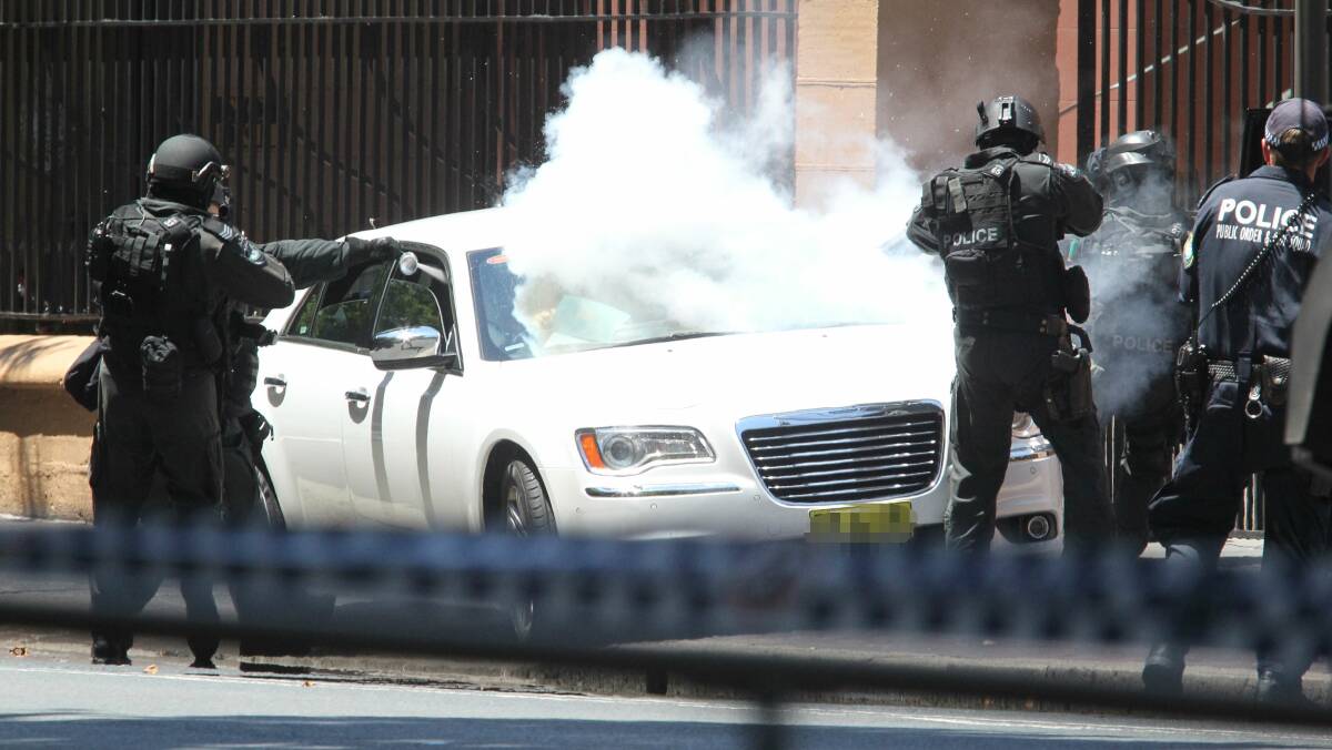 Police storm the car outside Parliament House. Picture: PETER RAE