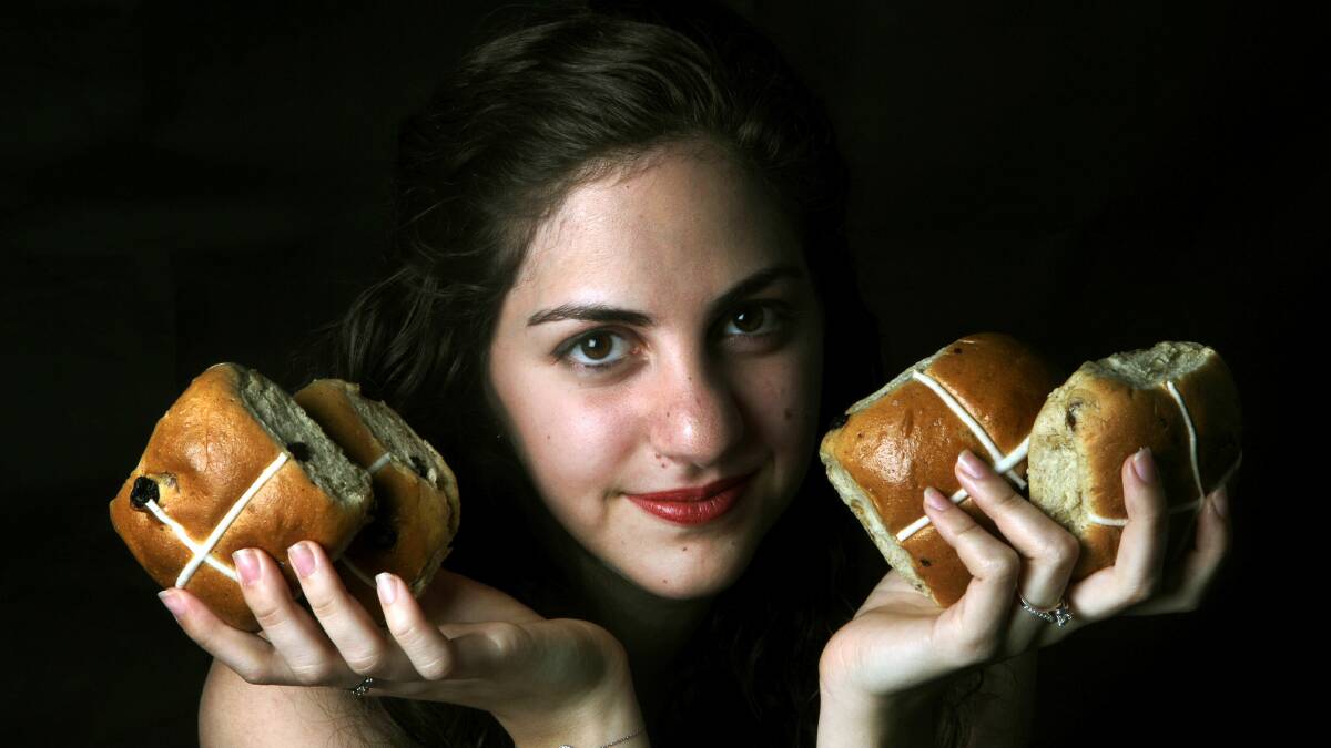 Gemma Khaicy holds some of the hot cross buns that will sell in their millions. Picture: SYLVIA LIBER