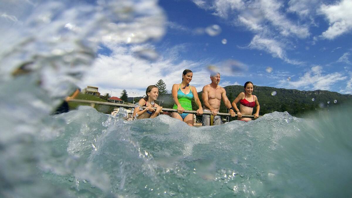 Alyssa, Lisette, Simon and Amelie Abbott enjoy the king tide. Picture: KIRK GILMOUR
