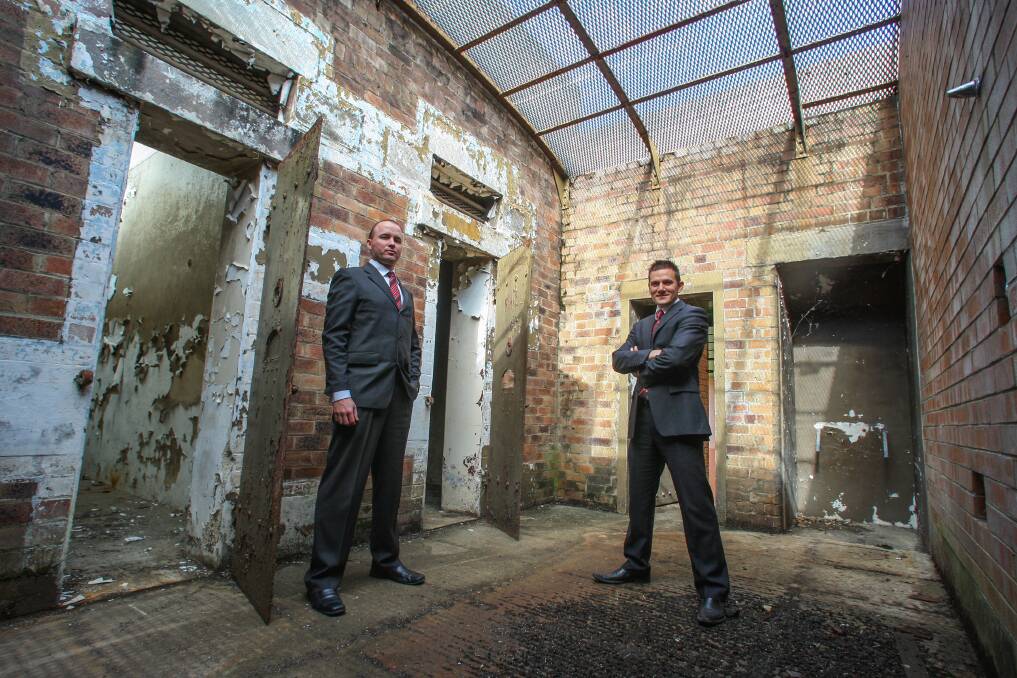 Real estate agents Tim Jones (left) and Travis Machan  check out the old holding cells.