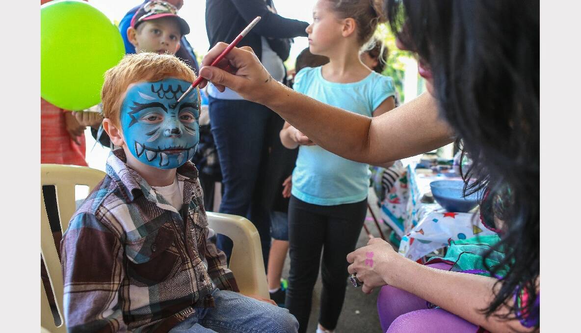 Three-year-old Ocean gets his face painted by Eliese Vohradsky. Picture: ADAM McLEAN
