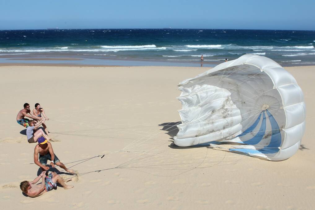 Parachute play at Wollongong's North Beach. Picture: SYLVIA LIBER