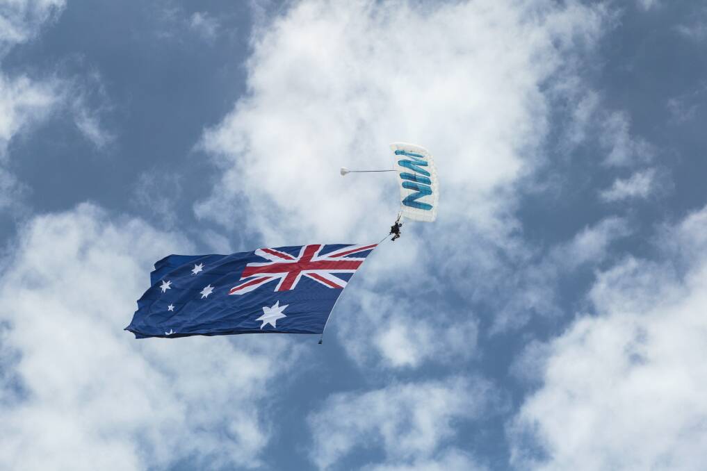 A flag-bearing skydiver over Wollongong. Picture: CHRISTOPHER CHAN