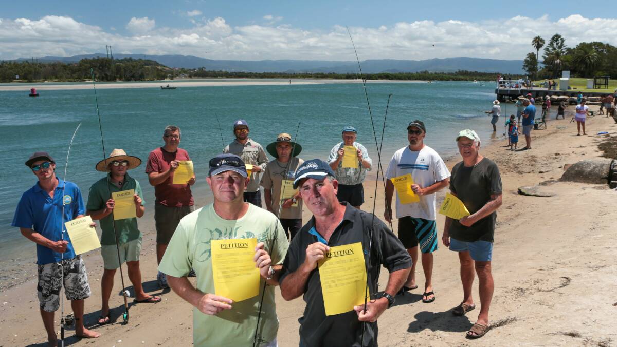 Sam Carriage (front left) and Andrew Connor (front right) on the Windang lake shore with fishermen who want commercial licences limited. Picture: ADAM McLEAN