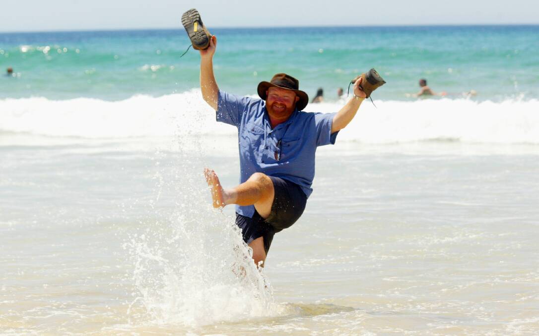 Trekker Rodney Horan makes a splash at Port Kembla Beach after walking 4500km from Perth to raise funds for cancer research.