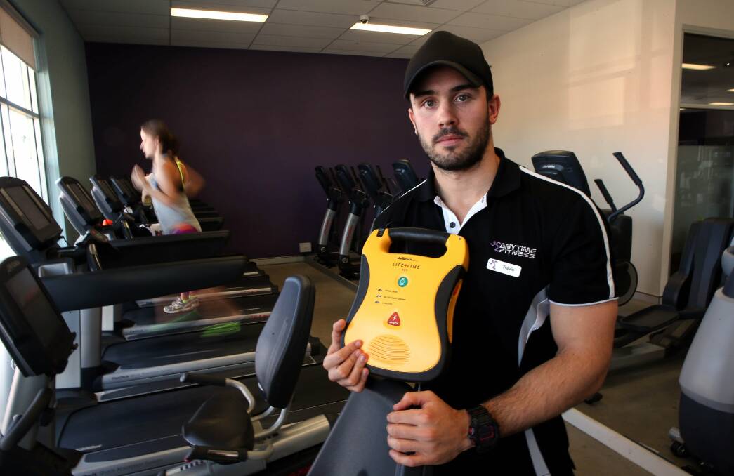 Personal trainer Travis Roche holds a defibrillator used to save a man after he suffered a heart attack. Picture: KIRK GILMOUR