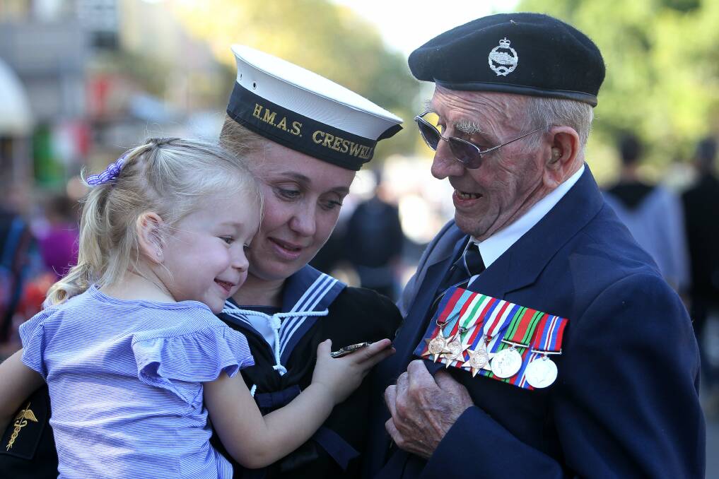 Ebony admires the service medals of her great-grandfather, Fred Gregory, as she is held by her mother Kelly Gallagher. 