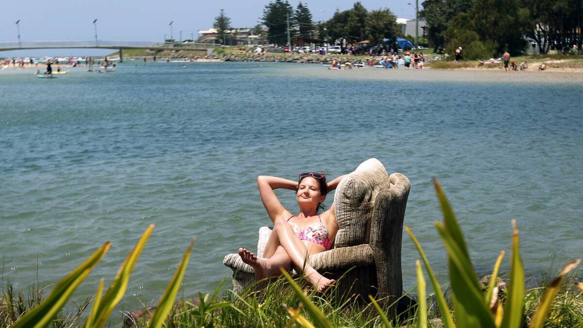 Rebecca Ambrose, of Sydney, reclines on a pre-loved sofa that was dumped on the rocks at Little Lake, Barrack Point. Picture: SYLVIA LIBER