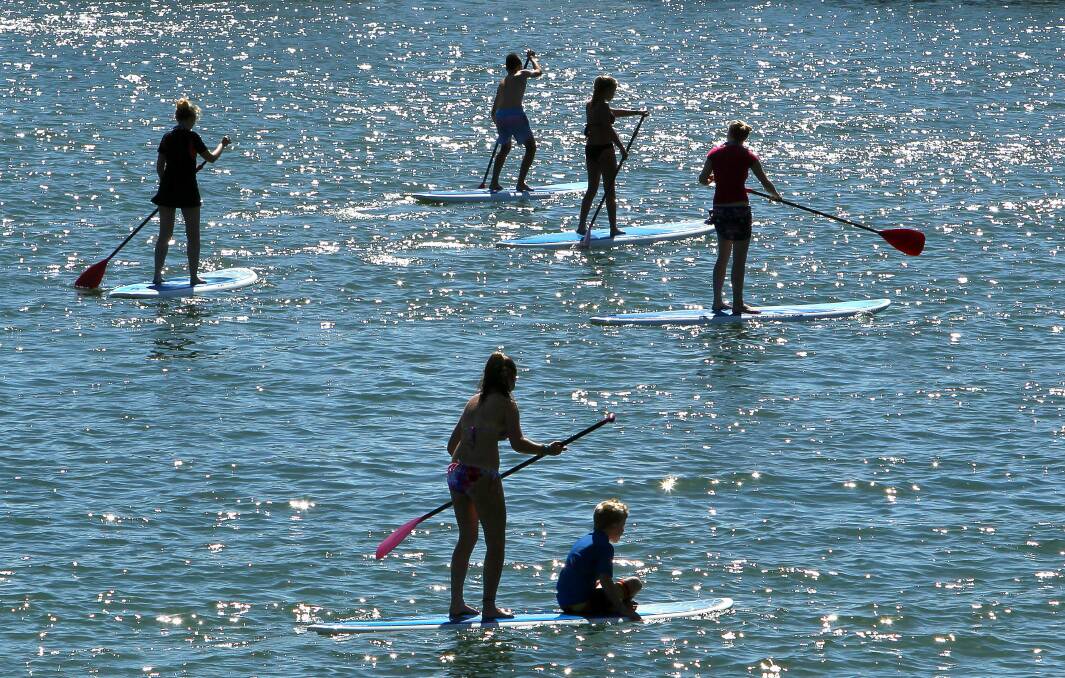 Kids learning to paddle board in Wollongong Harbour during the last week of school holidays. Picture: KIRK GILMOUR