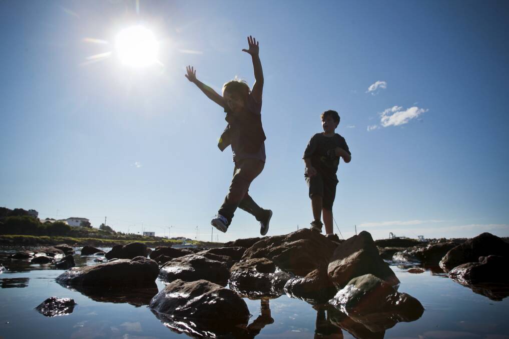 Riley, 8, and Levi, 8, enjoy a spot of rock-hopping at Shellharbour Harbour in July. Picture: DAVE TEASE