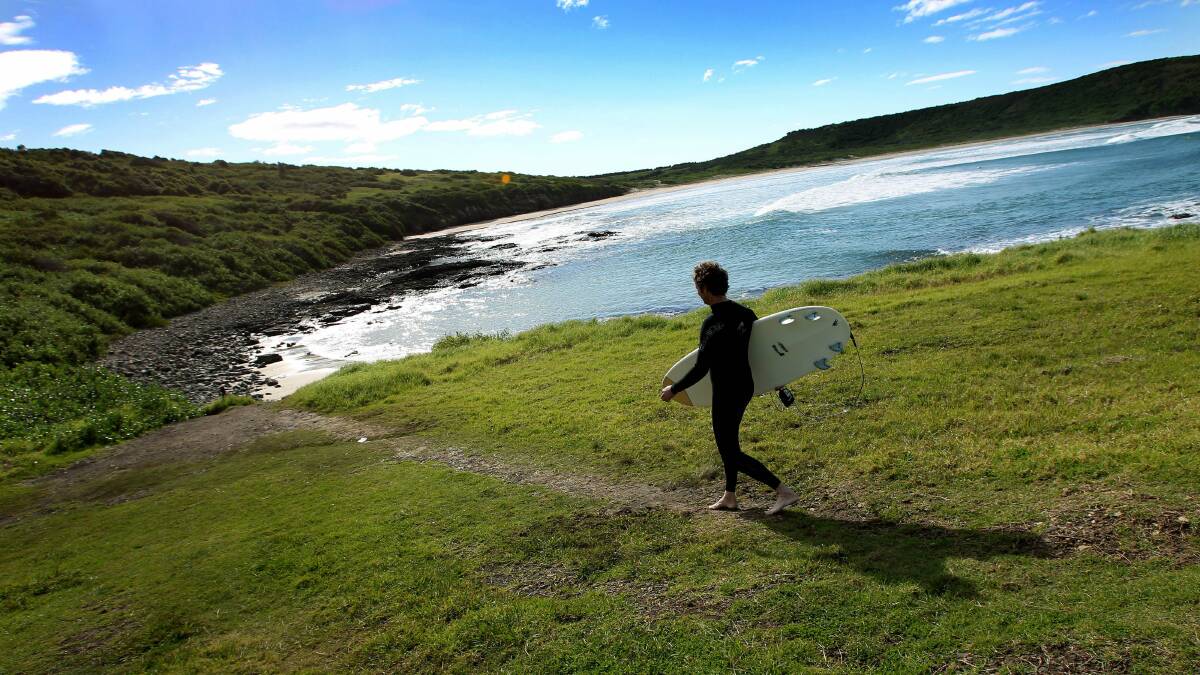 A surfer makes his way to The Farm at Killalea State Recreation Area.