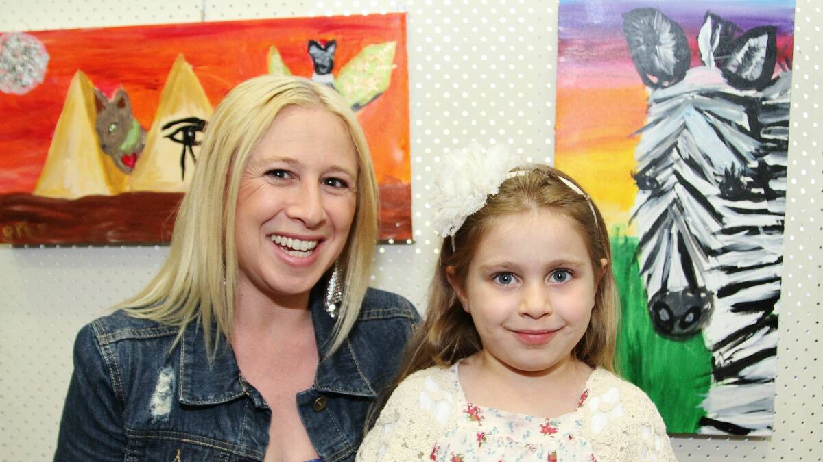 Sonia and Sumehra Sozio, 5, with a winning artwork by the young artist  at Kiama Leagues Club. Picture: GREG ELLIS