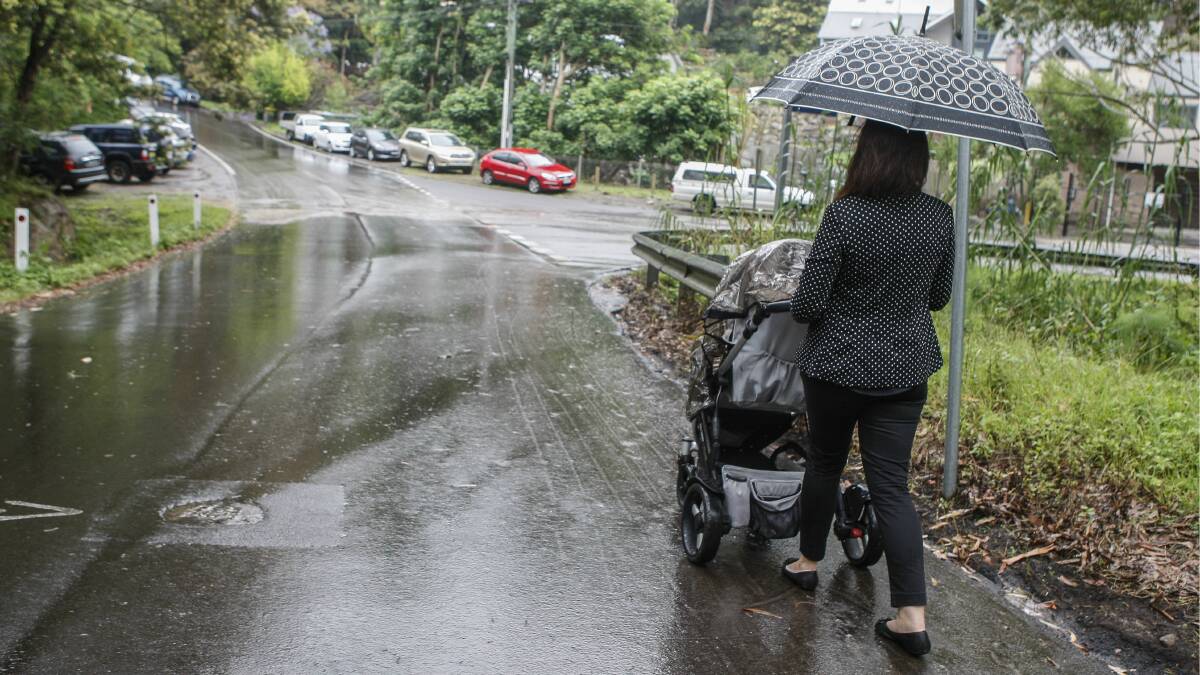 Mercury reporter Kate Walsh braves the wet and narrow streets with a pram and umbrella. Pictures: KIRK GILMOUR