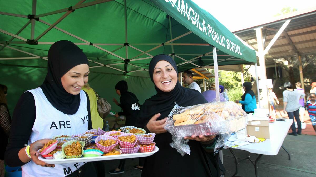 Mother and daughter Batoul and Nadia Hamid deliver trays of food for Cringila’s Primary School’s first fete. Pictures: SYLVIA LIBER