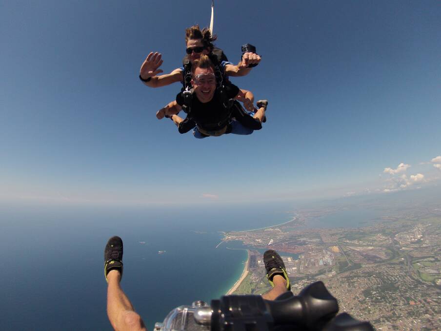 ‘‘Chief Funster’’ for NSW Andrew Smith floats over the Illawarra on Friday, all in a day’s work. Picture: SKYDIVE THE BEACH