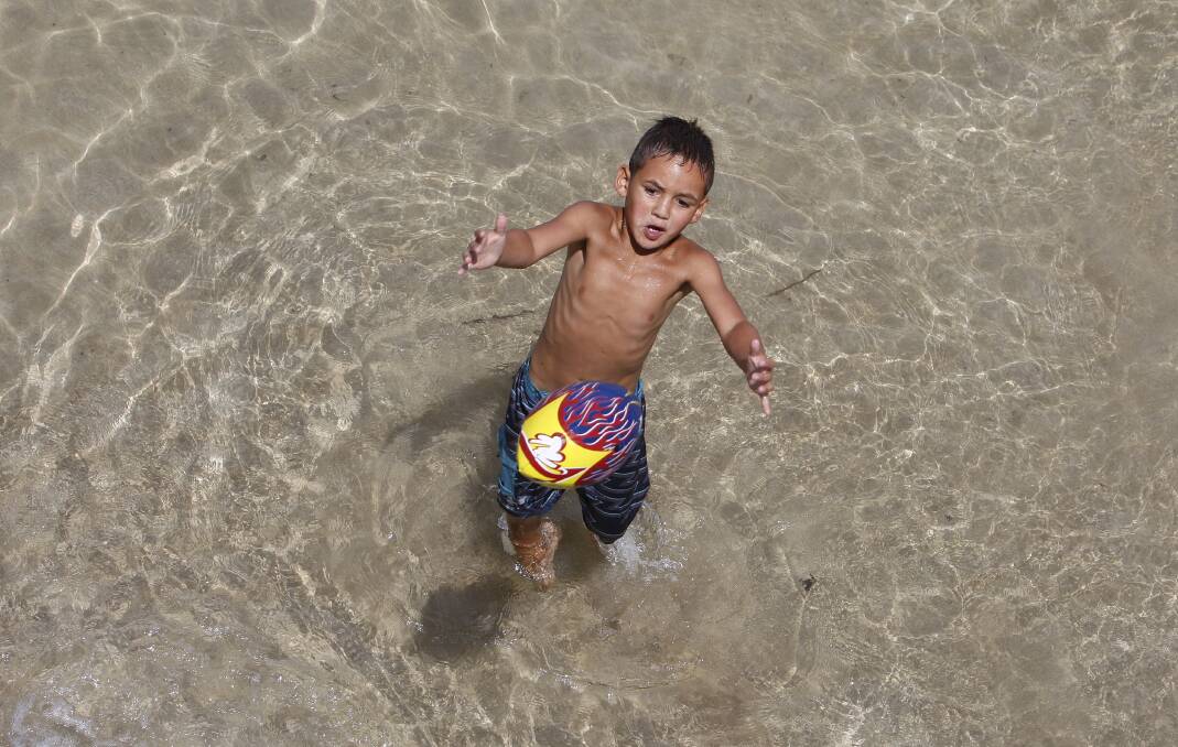 Tristian, 6, plays  in Little Lake at Warilla Barrack Point.