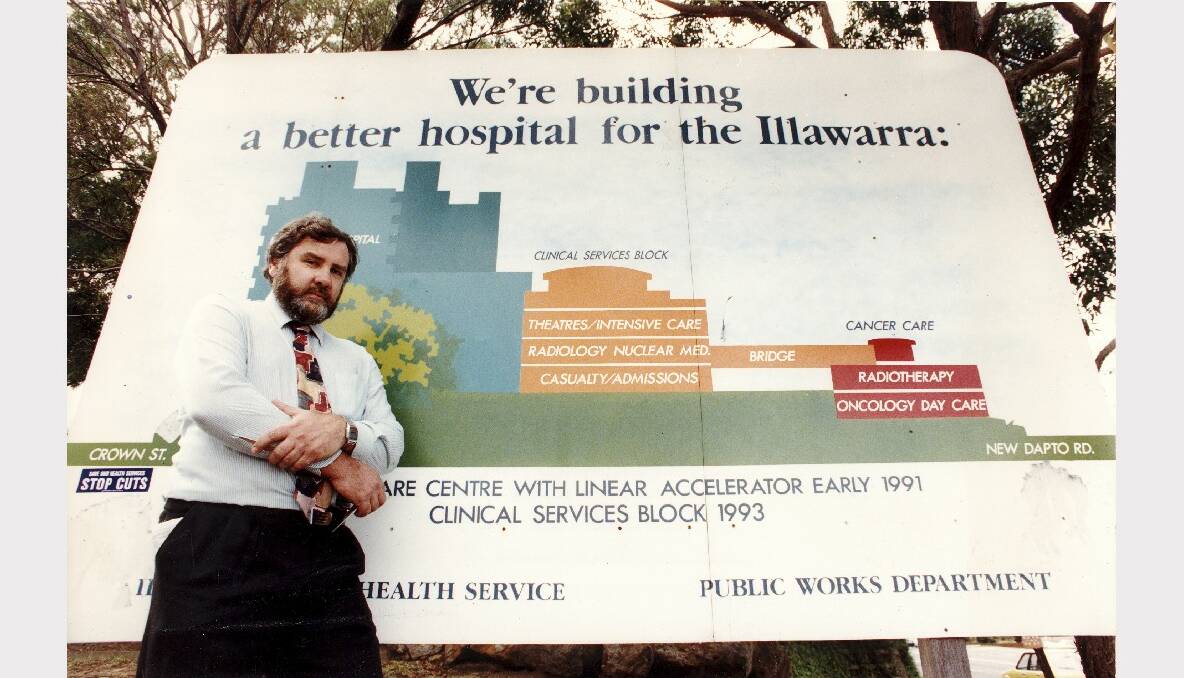 1993: In front of a sign for the behind-schedule clinical services block at Wollongong Hospital. 