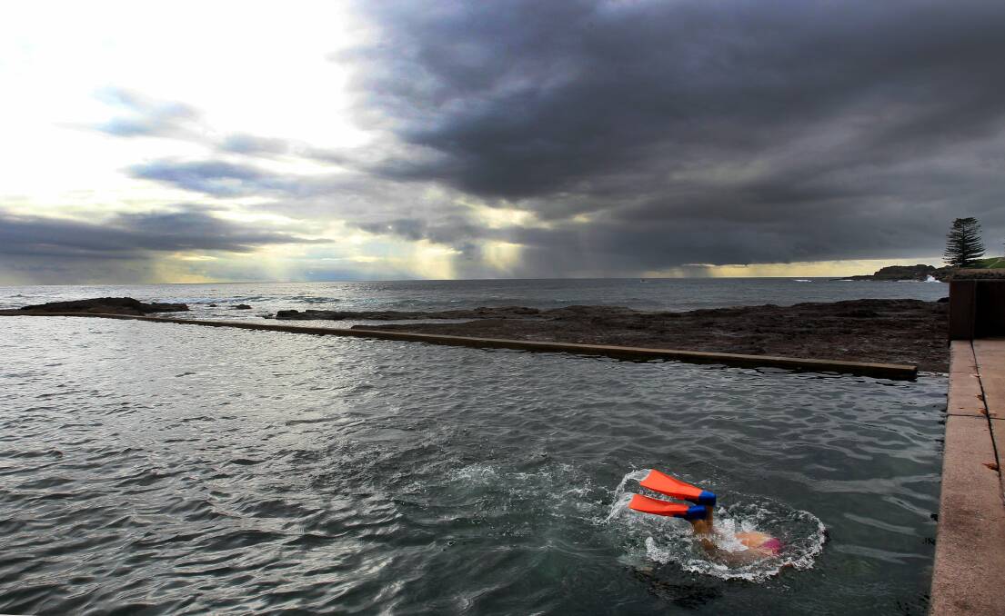 Joan Johnson takes a dip in a Kiama rock pool as clouds gather on February 16. Picture: ORLANDO CHIODO