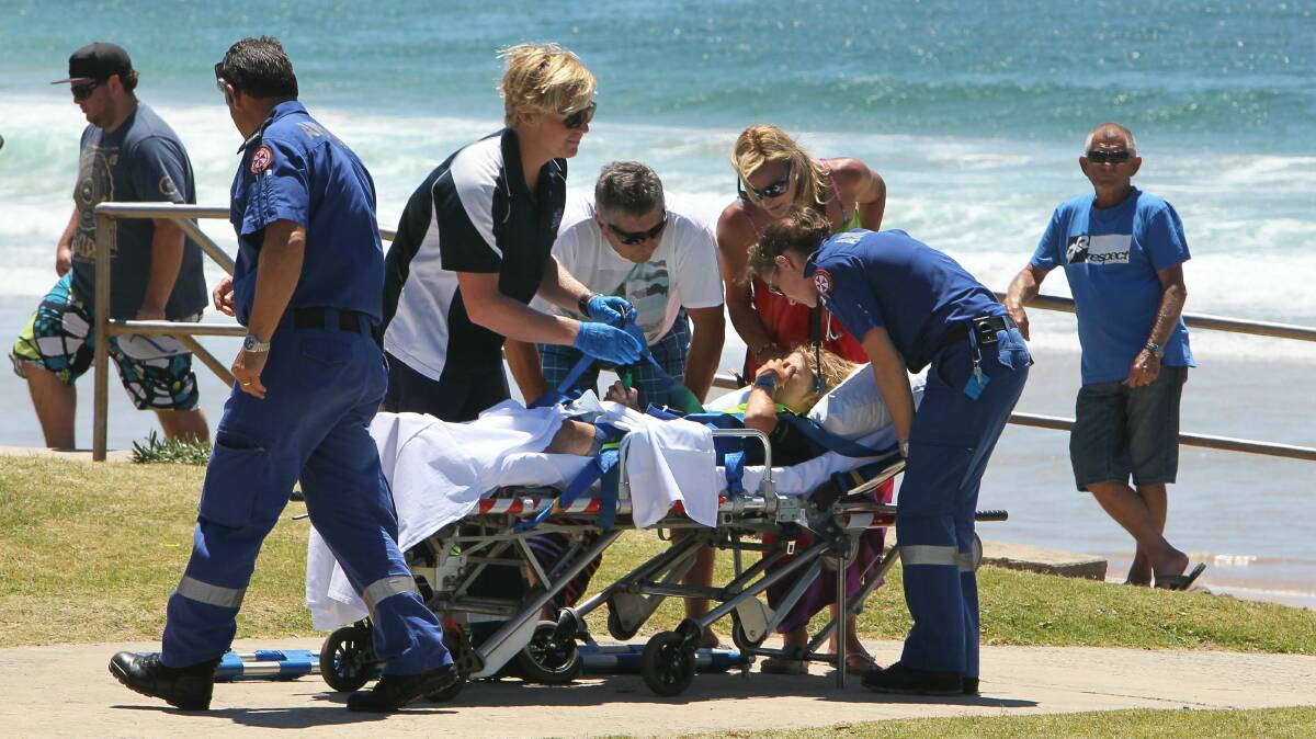 The teen is stretchered from Towradgi Beach after the speargun accident. Pictures: KIRK GILMOUR