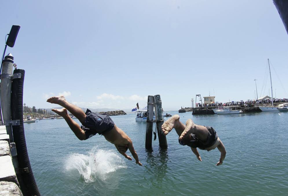 Swimmers dive for the holy cross in Wollongong Harbour. Pictures: DAVE TEASE