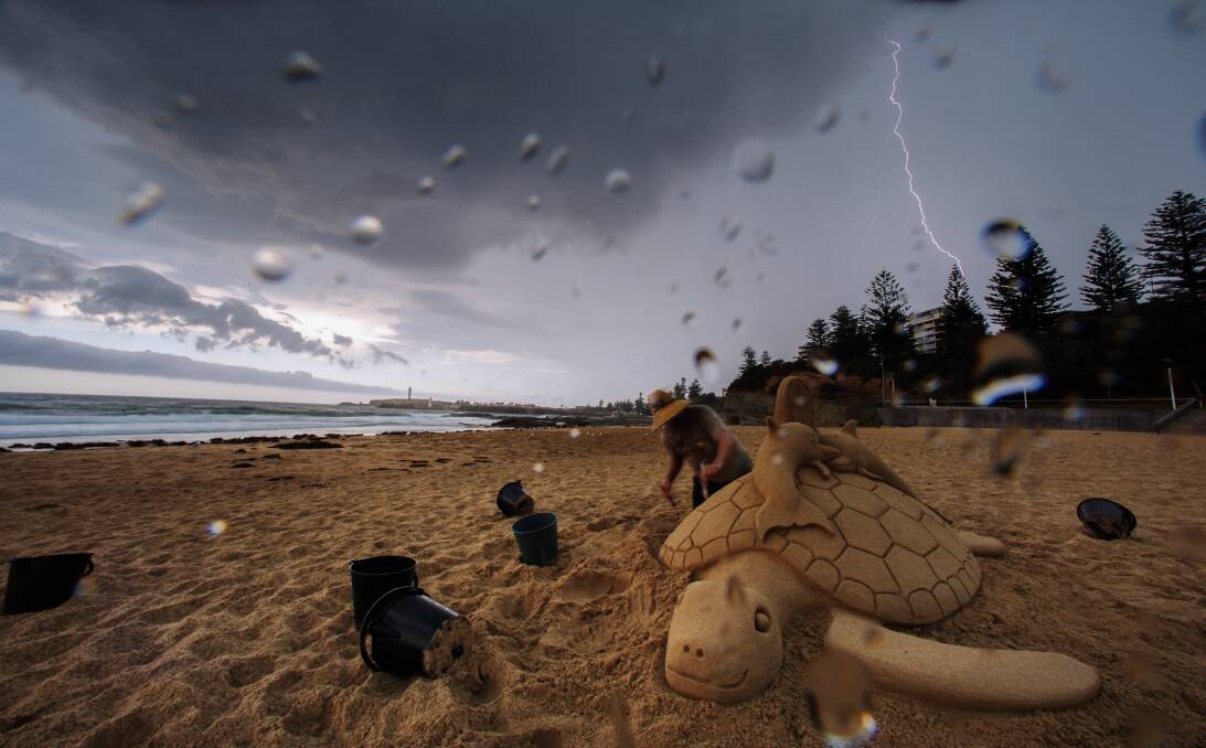 Sand sculpter Steve Machell on North Beach as a thunder storm rolls in on January 22. Picture: ADAM McLEAN