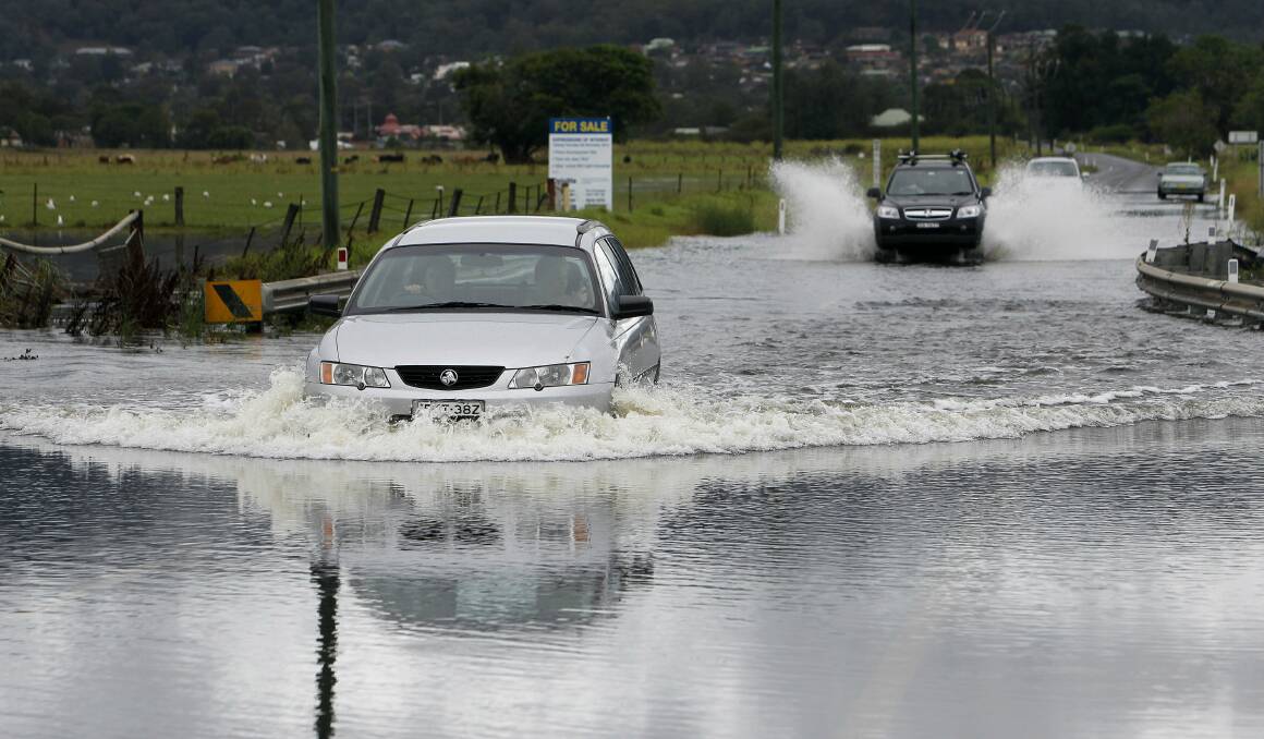 The Illawarra Highway at Albion Park inundated by flood yesterday. The road has been reopened today. Picture: ANDY ZAKELI