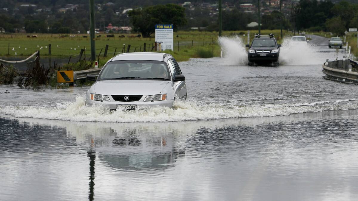 While the Princes Highway at Albion Park is closed due to flooding, some motorists are still chosing to brave the waters. Pictures: ANDY ZAKELI