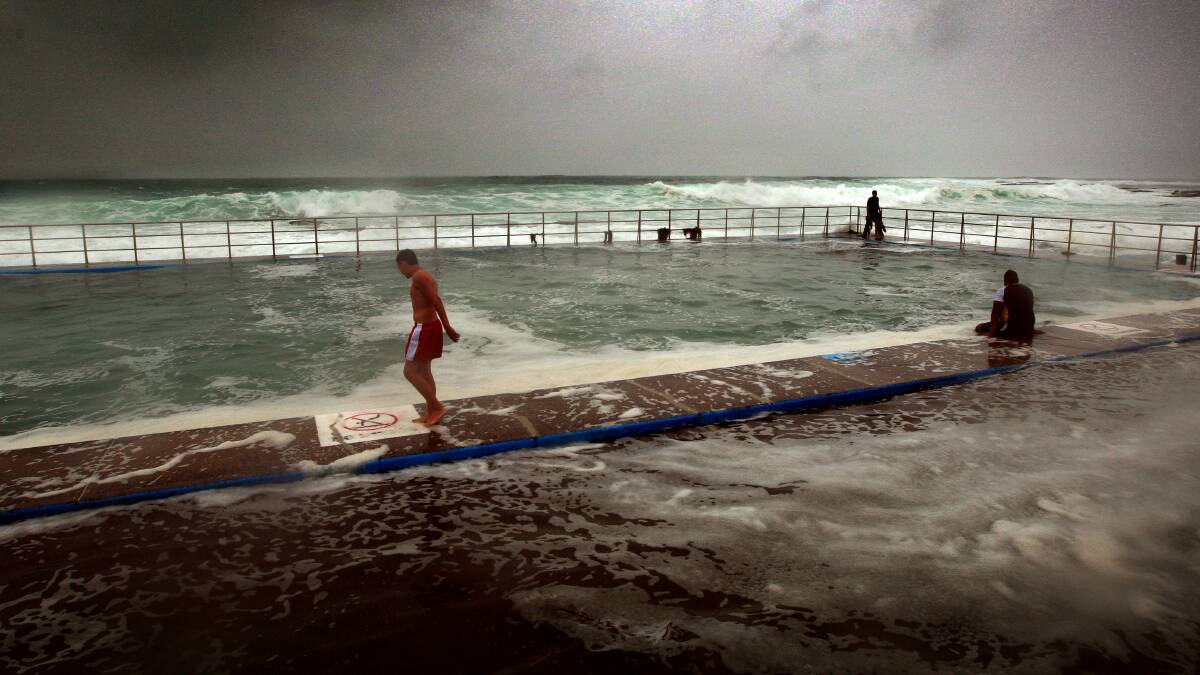 Swimmers at Shellhabour ocean pool brave the conditions. Picture: SYLVIA LIBER