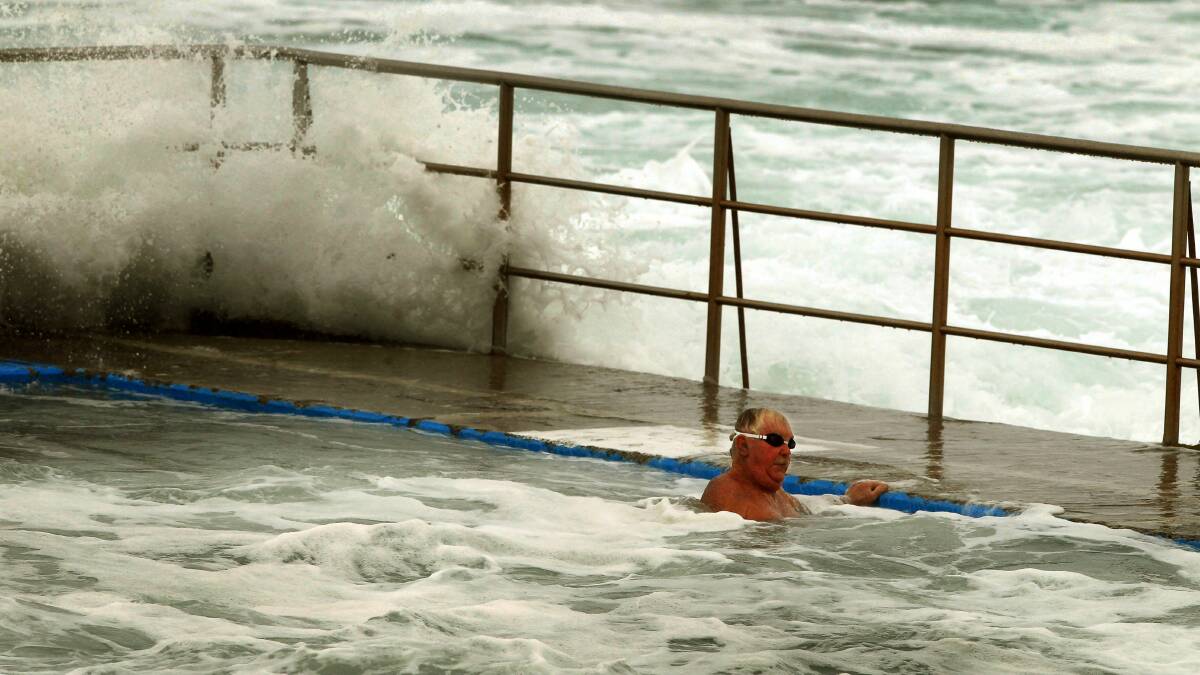 Swimmers at Shellharbour ocean pool brave the conditions. Picture: SYLVIA LIBER