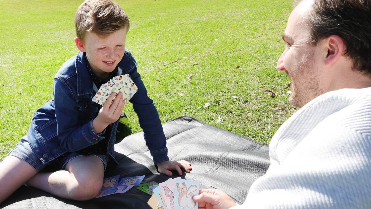 Levi Turner and his dad Evan Turner playing their card game Go Bum in Lang Park, Wollongong. Picture by Sylvia Liber