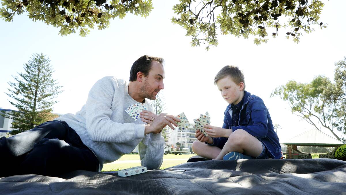 Evan Turner and his son Levi Turner playing their card game Go Bum in Lang Park, Wollongong. Picture by Sylvia Liber