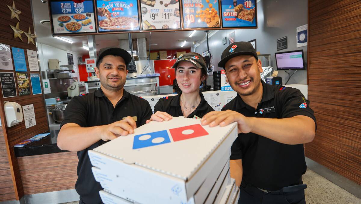 Woonona franchisees Subash KC, Sovit Nakarmi and store manager Tatum Fulton (centre) after the branch broke a store record for the number of pizzas sold in one night. Picture by Wesley Lonergan