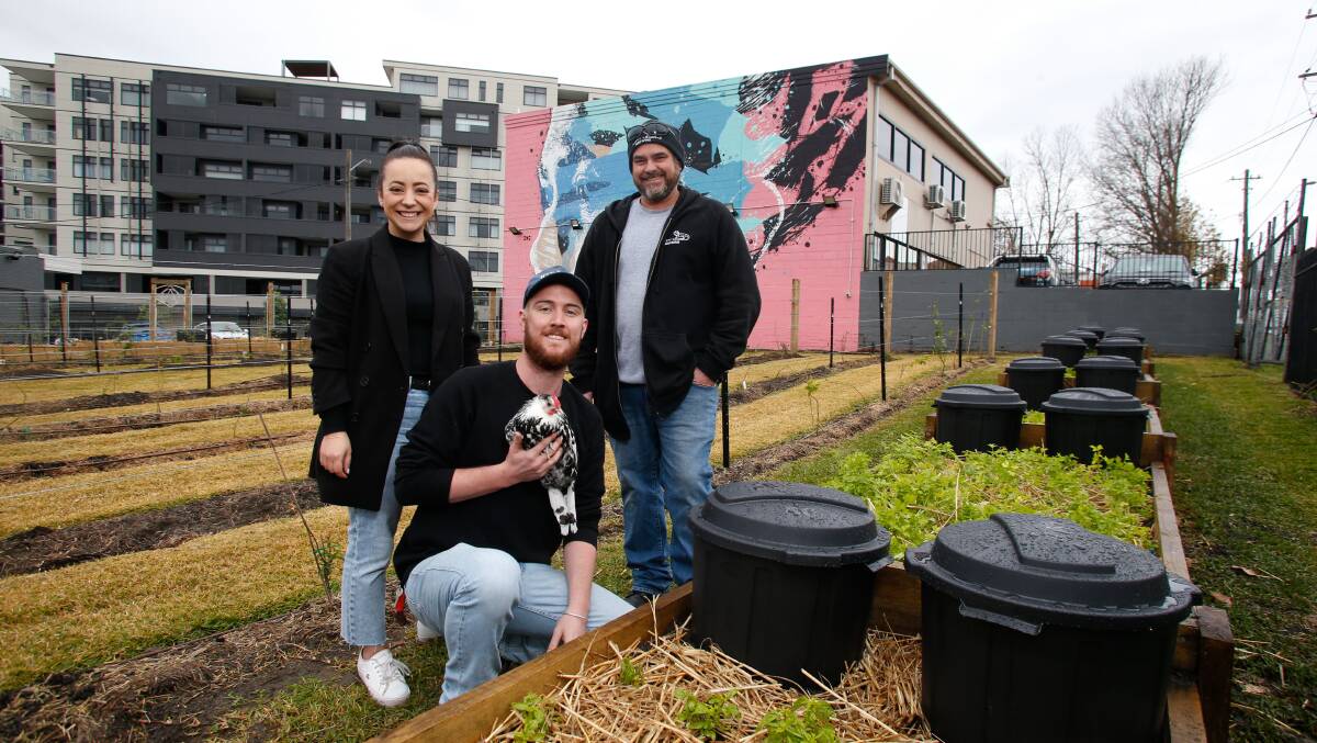 Green thumbs: Nikki Aitchison, Liam Fraser and Nathan Harris with one of the urban farm's chickens. Picture: Anna Warr