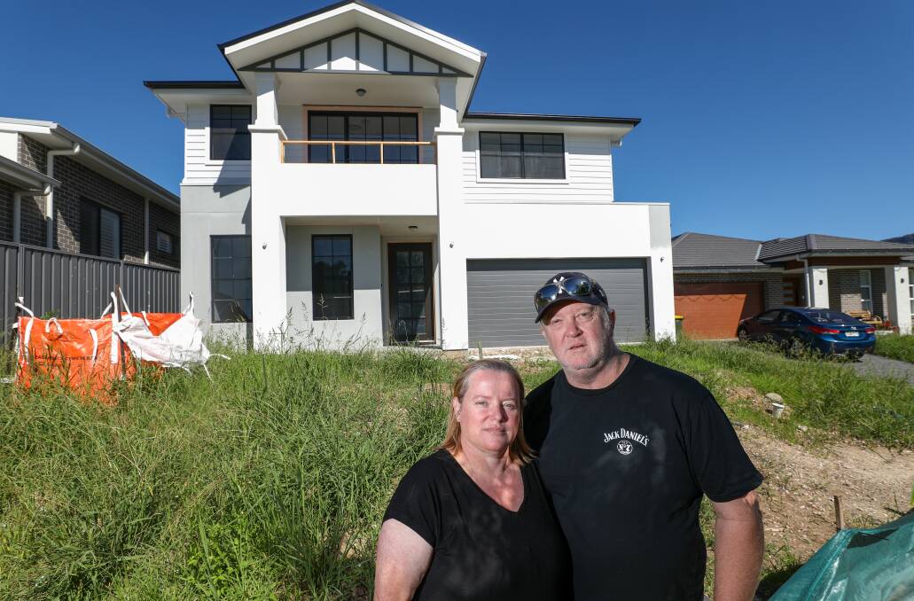 Kelly and Tony Sharples outside their partially constructed home, left unfinished after builder Elderton Homes collapsed. Picture by Adam McLean